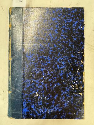 un vieux livre à la couverture bleue posé sur une table