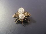 une broche en forme d'abeille en or et diamants sur un fond noir