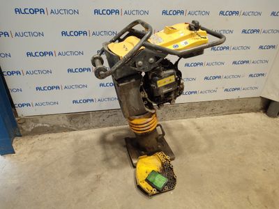 un gros plan d'un petit moteur posé sur un support devant un mur