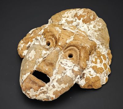 une image représentant un masque en argile sur un fond noir