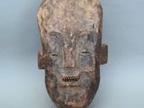 une image représentant un masque en bois sur fond bleu