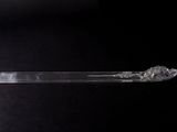 a plastic spoon with a clear handle on a black surface