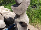 une statue en pierre posée sur un banc en bois