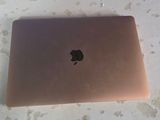 an apple laptop sitting on a table in a room
