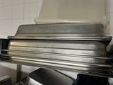 a stack of pans sitting on top of a rack in a kitchen