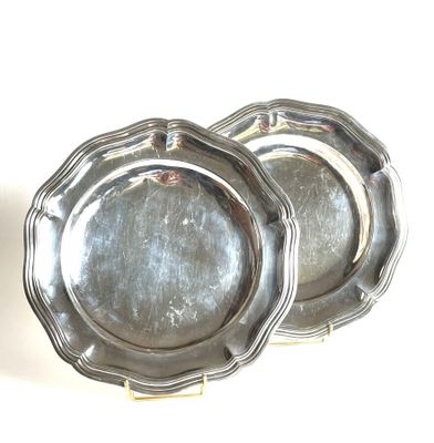 two silver plates sitting on a white surface