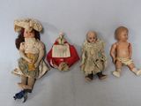 three antique dolls sitting next to each other on a white surface