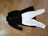 a black and white jacket and white pants on the floor