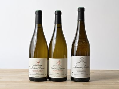 trois bouteilles de vin sont alignées sur une table en bois