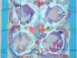 a close up of a blue scarf with fish on it