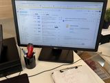 a computer monitor sitting on a desk in an office