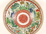 a red and white plate with a floral design on it