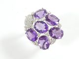 a close up of an amethorate and diamond ring on a white background