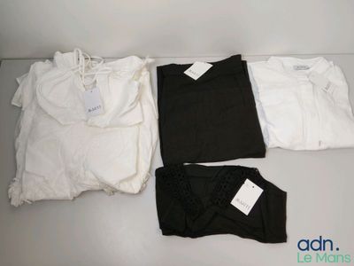 Trois paires de chemises noires et blanches sont posées sur une table blanche.