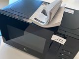 un micro-ondes posé sur une table, avec un livre dessus