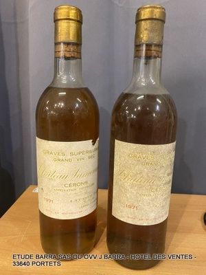 two bottles of wine sitting on top of a wooden table