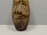 a brown glass vase sitting on a white table