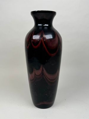 un vase noir orné d'un motif en spirale rouge