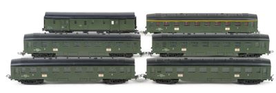four green train cars sitting next to each other on a white surface