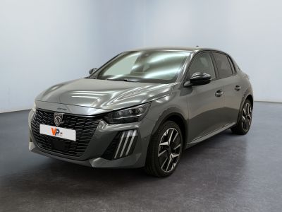 Une voiture grise est garée dans une pièce au sol noir.