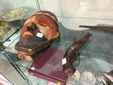 une vitrine contenant un masque, un pistolet et d'autres objets