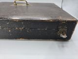 a black suitcase with a metal handle on a white surface