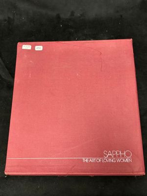 a red book sitting on top of a black cloth covered table