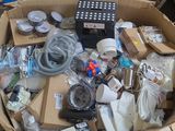 une boîte remplie d'appareils électroniques et d'autres objets posée sur la table