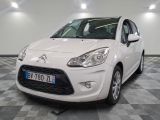 la petite voiture blanche est garée sur un sol en damier