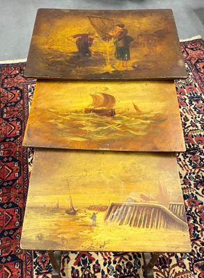 trois tables en bois ornées de peintures, posées sur un tapis