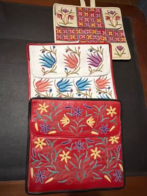 two purses sitting on a table with a cross in the background