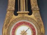 une horloge dorée ornée d'un motif rouge et blanc
