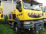two yellow trucks parked next to each other in the grass