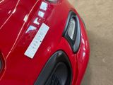 a red car with a sticker on the hood of it
