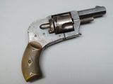 an old revolver with a wooden handle on a white surface