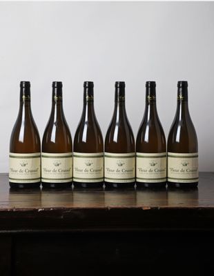 six bouteilles de vin sont alignées sur une table en bois