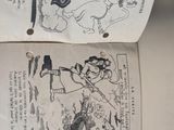 two pieces of paper with drawings on them on a table