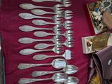 de nombreuses cuillères en argent et des cuillères à soupe posées sur une table