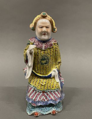 a figurine of a woman in a yellow dress holding a bag