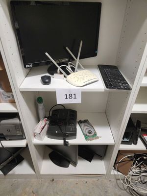un ordinateur de bureau et un ordinateur portable posés sur une étagère dans un placard