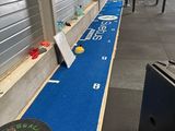 a gym area with a blue floor and a row of exercise equipment