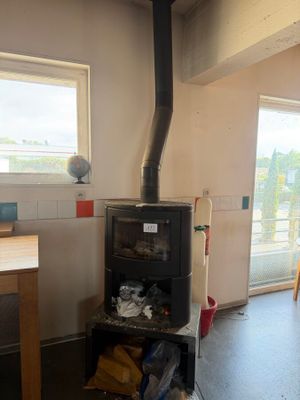 a small stove in the middle of a room with a table and chairs