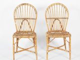 pair of wicker chairs with arms and backrests on a white background