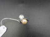 un gros plan d'une bague ornée d'une perle et d'une étiquette