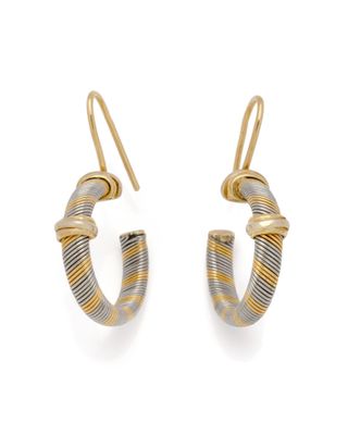 une paire de boucles d'oreilles créoles dorées et argentées sur fond blanc