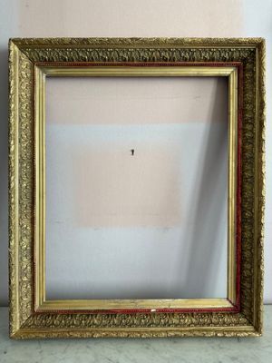 un vieux cadre photo posé sur une table, avec un mur en arrière-plan