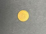 gros plan d'une pièce d'or sur une surface noire