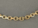 a close up of a gold chain on a gray surface