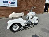 a white motor scooter parked in front of a building