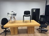 chairs and a table in a room with a refrigerator in the background